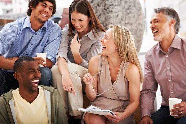 Sharing a laugh with coworkers. A team of designers laughing while looking at some ideas. — Stock Photo, Image