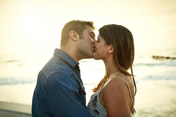 Romans w raju. Przycięte ujęcie czułej młodej pary całującej się stojąc na plaży. — Zdjęcie stockowe