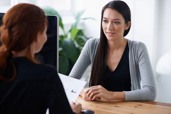 Dis-moi quelque chose sur toi qui n'est pas dans ton CV. Prise de vue de deux jeunes professionnels en train de discuter à un bureau. — Photo