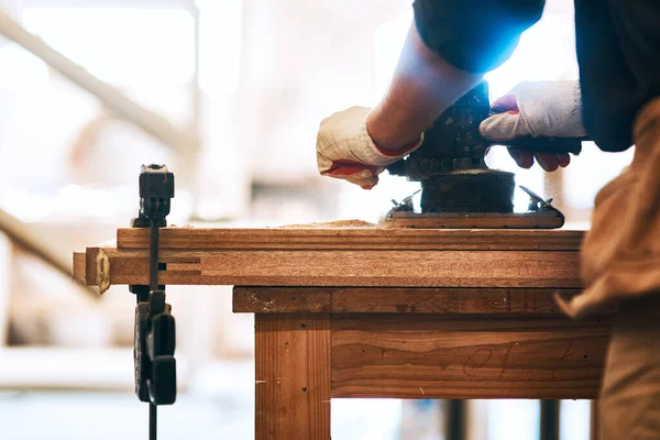 Slipning till perfektion. Beskär skott av en oigenkännlig snickare sandning trä med en handflata sander inne i en verkstad. — Stockfoto