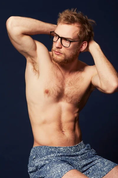É um hipster macho. Vista cortada de um homem musculoso vestido de shorts e óculos hipster. — Fotografia de Stock