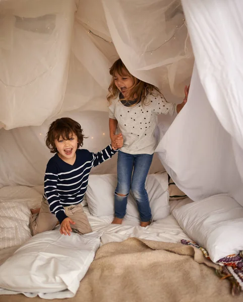 Les meilleurs souvenirs sont faits avec mon frère. Tourné de deux adorables frères et sœurs sautant sur le matelas sous leur fort. — Photo