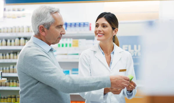 I think you chose well. Shot of a pharmacist assisting a customer in a chemist. — Stock Photo, Image