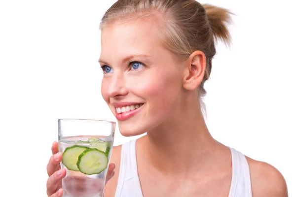 Levenslust. Shot van een mooie jonge vrouw met een glas water met komkommer plakjes geïsoleerd op wit. — Stockfoto