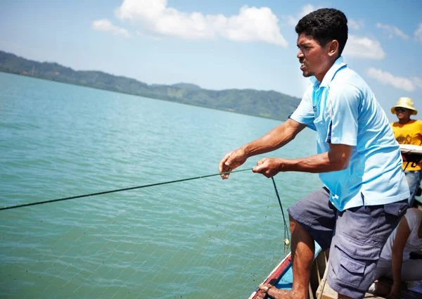 Boa captura. Pescador tailandês puxando em um lanço em seu barco de pesca - copyspace. — Fotografia de Stock