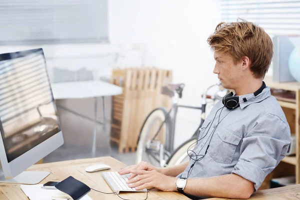 Trabaja duro. Un joven diseñador usando su computadora mientras está sentado en la oficina. — Foto de Stock