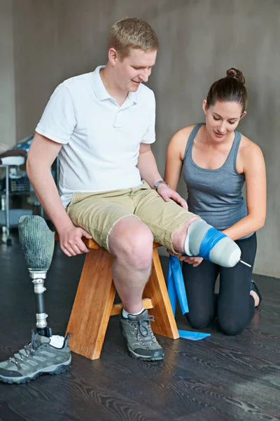 Hij vordert beter dan ze hoopte. Foto van een vrouwelijke fysiotherapeut met een sessie met een jonge mannelijke geamputeerde. — Stockfoto