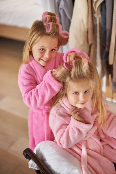 So tun, als ob sie im Schönheitssalon wären. Schnappschuss von zwei jungen Schwestern, die mit Mamas Make-up spielen. — Stockfoto