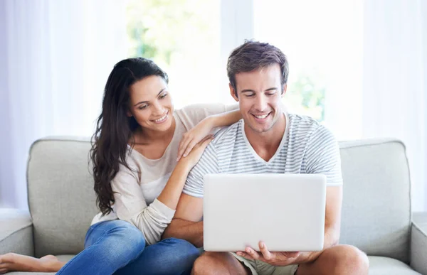 A comprare la loro nuova casa. Una giovane coppia si rilassa sul divano utilizzando un computer portatile. — Foto Stock