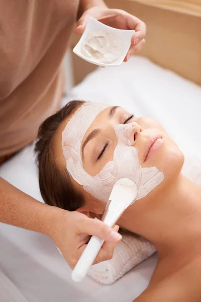 Aplicando una máscara de belleza. Primer plano de un terapeuta de belleza aplicando una mascarilla facial a un cliente. — Foto de Stock