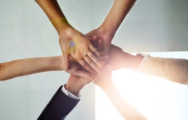 Condividere l'obiettivo, condividere il successo. Colpo basso di un gruppo di colleghi che si uniscono le mani in solidarietà. — Foto Stock