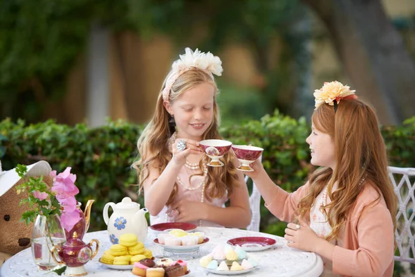 信じられないほどのお茶会を開く。裏庭で茶会を開いてる2人の若い女の子. — ストック写真