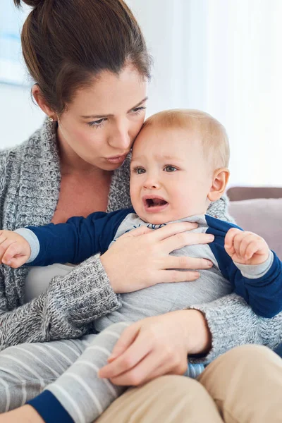 Huil niet mijn engel, mama is hier. Gehakt schot van een moeder proberen om haar huilende baby jongen troosten thuis. — Stockfoto