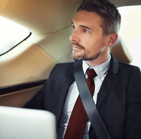 Planning his day ahead. Cropped shot of a businessman in the backseat of a car. — Stock Photo, Image