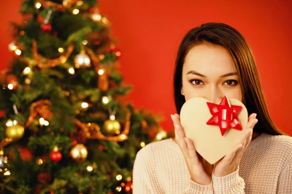 Kan niet wachten om het te openen. Portret van een aantrekkelijke jonge vrouw die haar kerstcadeau omhoog houdt. — Stockfoto