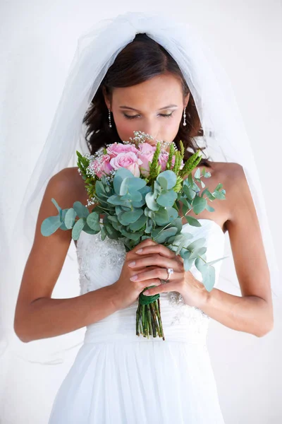 Hanno un profumo bellissimo come il look. Una splendida giovane sposa che annusa il suo bouquet. — Foto Stock