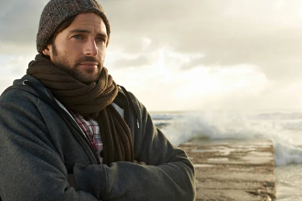 Han trivs med att vara nära havet. En stilig ung man på stranden. — Stockfoto