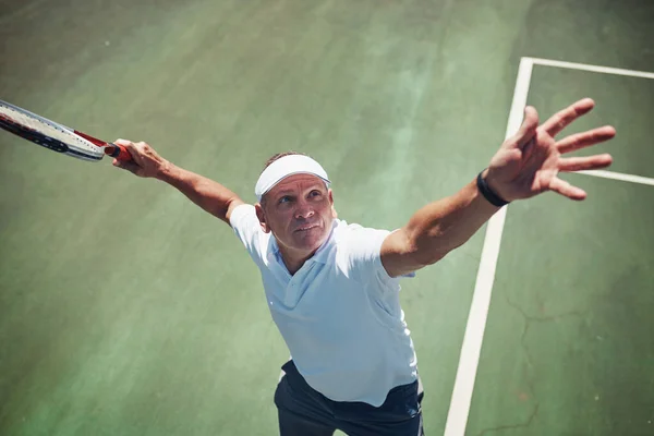 Готовий, готовий, йди. Високий кут стрільби красивого зрілого спортсмена, який грає в теніс один на дворі протягом дня . — стокове фото
