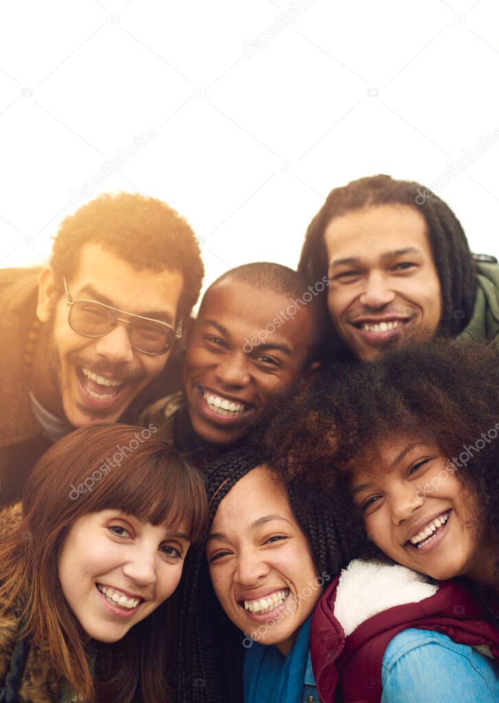 Friends are the family we choose. Portrait of a happy group of friends posing together outside.