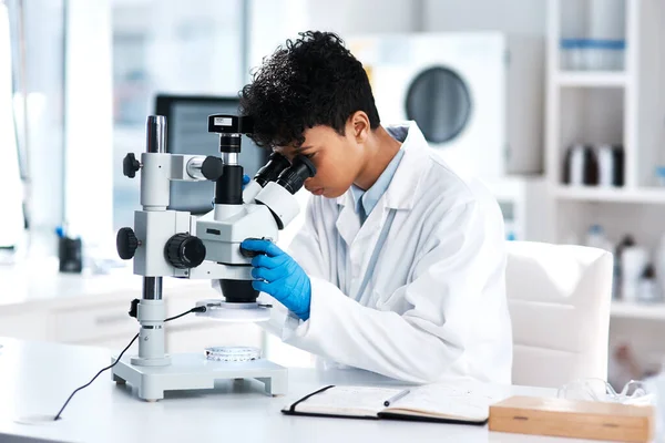 私たちの周りの世界について発見することがたくさんあります。研究室で顕微鏡を使って若い科学者のショット. — ストック写真