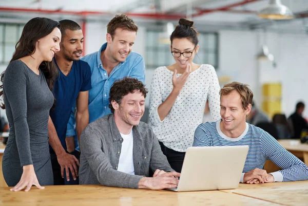 A technológia is a csapatuk része. Lőtt egy csapat kolléga használ egy laptop együtt alkalmi munkakörnyezetben. — Stock Fotó
