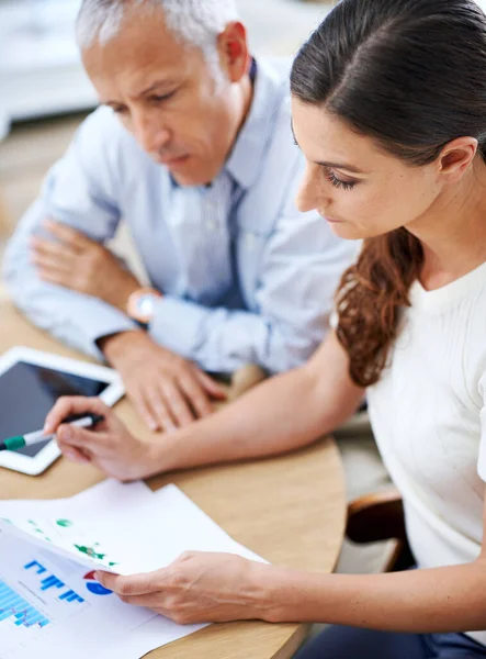 Kopf runter und harte Arbeit. Aufnahme von zwei Kollegen, die Papierkram lesen, während sie am Schreibtisch in einem Büro sitzen. — Stockfoto