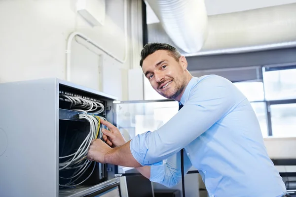 Estará online daqui a um minuto. Retrato de um engenheiro de computação sorridente trabalhando em um servidor. — Fotografia de Stock