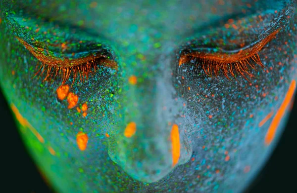 Su belleza brilla en la oscuridad. Foto de una joven posando con pintura de neón en la cara. —  Fotos de Stock