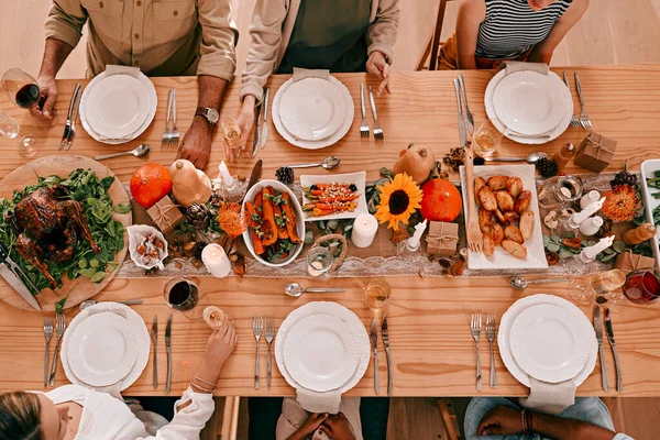 Соберитесь вокруг стола, пришло время поблагодарить. Высокоуровневый снимок группы друзей, которые вместе ужинают на День Благодарения. — стоковое фото