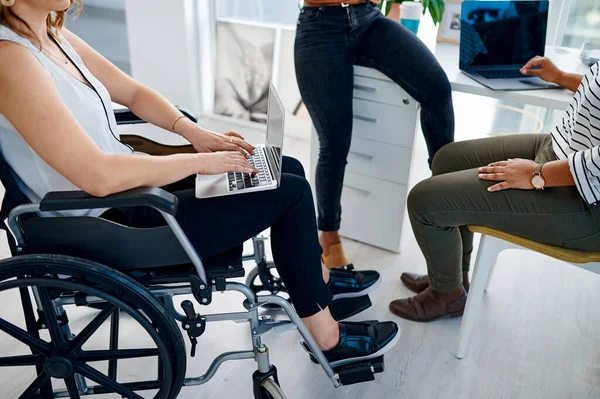 Utiliser Internet pour prendre des décisions éclairées. Prise de vue d'une femme d'affaires handicapée assise avec des collègues au bureau. — Photo