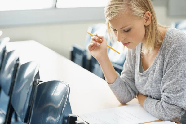 Fokuserade på studierna. En vacker collegestudent studerar i ett klassrum. — Stockfoto