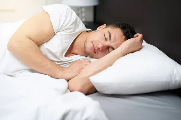 Den ganzen Schlaf zu bekommen, den sein Körper braucht. Schnappschuss eines hübschen jungen Mannes, der in seinem Bett schläft 0. — Stockfoto