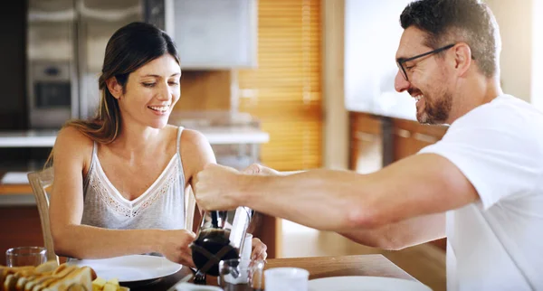 Some more coffee for you dear. Shot of a mature couple having breakfast together at home. — Stock Photo, Image