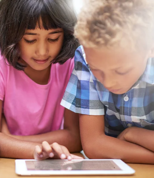 Descubrimientos inalámbricos. Inyección de niños de primaria usando una tableta digital mientras están sentados en clase. —  Fotos de Stock