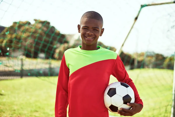 Chceš si zahrát na nohatce? Portrét mladého chlapce hrajícího fotbal na sportovním hřišti. — Stock fotografie