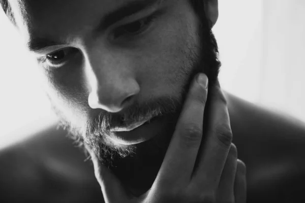 Pensive in black and white. Closeup of a handsome man rubbing his chin thoughtfully. — Stock Photo, Image