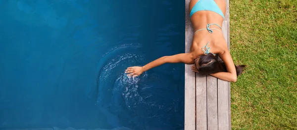Kaygısız yaz yağmuru. Yüzme havuzunda dinlenen güzel bir genç kadının fotoğrafı.. — Stok fotoğraf