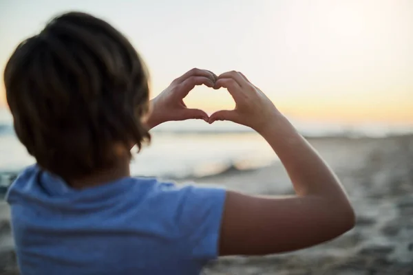 Mutluluk plajda bulunabilir. Sahilde elleri ile kalp şekli oluşturan genç bir kızın dikiz görüntüsü.. — Stok fotoğraf