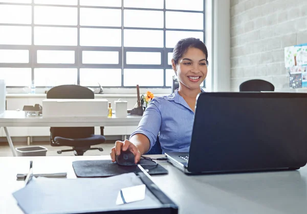 Det leende som kommer från att ha en framgångsrik karriär. Skjuten av en ung affärskvinna som använder en bärbar dator på jobbet. — Stockfoto