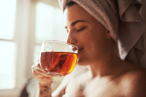 Jak milovníci čaje začínají své dny. Shot na mladou ženu s čajem, zatímco prochází její ranní krásy rutiny doma. — Stock fotografie
