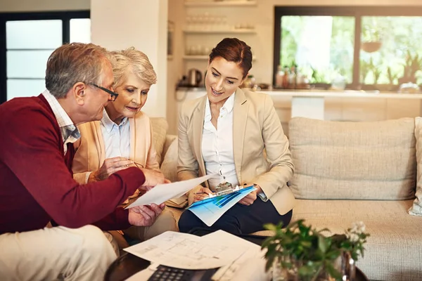 Het is tijd om te genieten van de vruchten van onze arbeid. Foto van een ouder stel dat advies krijgt van hun financieel adviseur. — Stockfoto