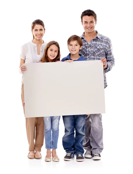 Наприклад. Студійний знімок щасливої сім'ї, що стоїть з чистим плакатом для копій . — стокове фото