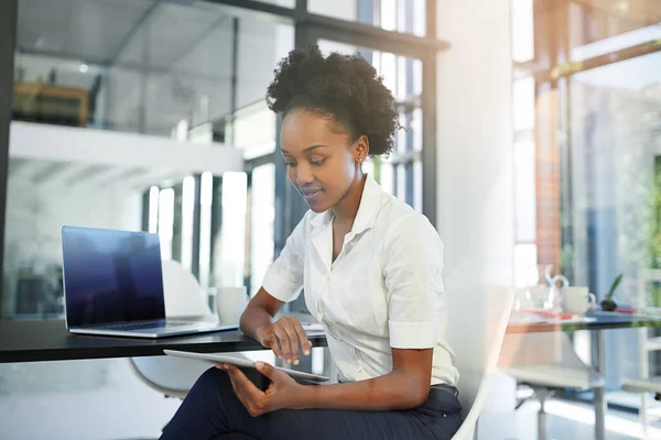 Trabajar duro para lograr el éxito. Imagen recortada de una joven empresaria que trabaja en una tableta digital en una oficina moderna. — Foto de Stock