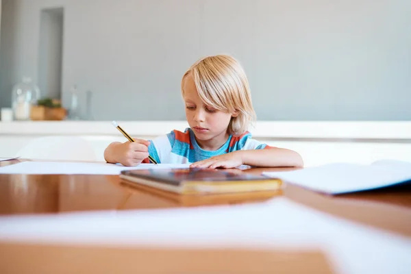 Vroege start van de academische wereld. Shot van een schattige kleine jongen doet zijn huiswerk thuis. — Stockfoto