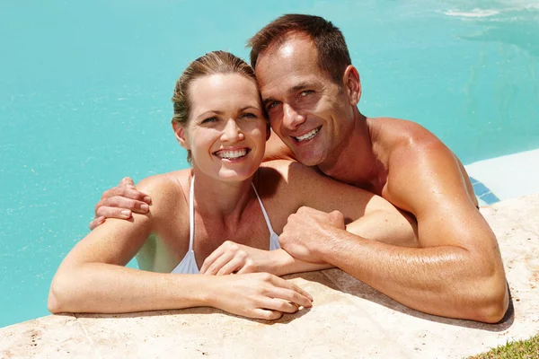 Tämä on elämää. Muotokuva miehestä, joka seisoo käsi vaimonsa ympärillä uima-altaassa.. — kuvapankkivalokuva
