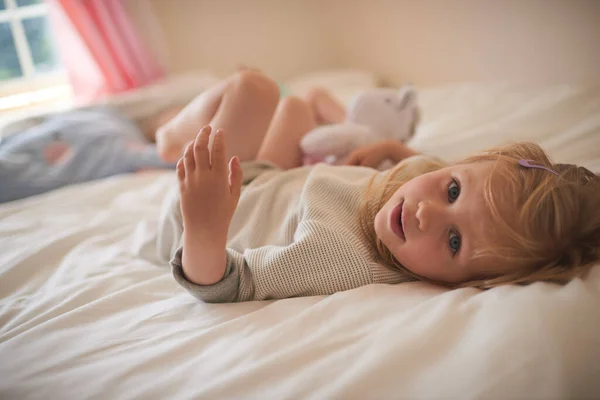 Zoveel zoetheid van een klein meisje. Portret van een schattig klein meisje ontspannen op het bed thuis. — Stockfoto