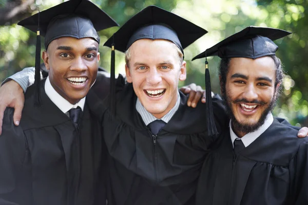 Tem sido difícil, mas finalmente conseguimos. Um grupo de estudantes felizes do sexo masculino no dia da graduação. — Fotografia de Stock