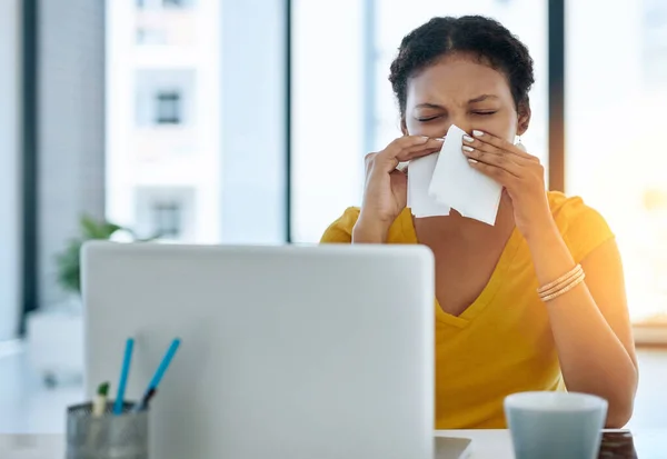 Ihr Immunsystem könnte einen Schub gebrauchen. Aufnahme einer jungen Designerin, die sich in einem Büro die Nase pustet. — Stockfoto