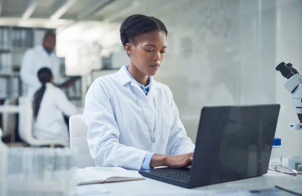 Je härter sie arbeitet, desto näher rückt die Heilung. Aufnahme eines jungen Wissenschaftlers mit einem Laptop bei Forschungsarbeiten in einem Labor. — Stockfoto