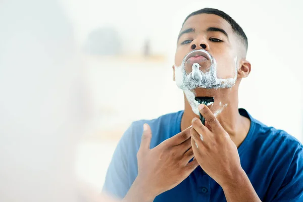 Biztosra kell mennem, hogy ezúttal rendesen borotválkozom. Egy fiatal férfi, aki a borotválkozásra koncentrál.. — Stock Fotó
